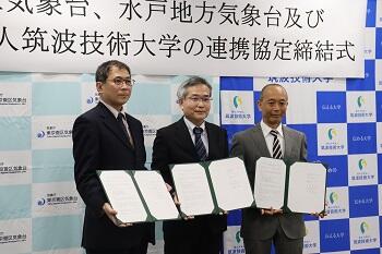 署名した協定書を持つ三井水戸地方気象台長（左）、多田東京管区気象台長（中央）、石原本学学長（右）
