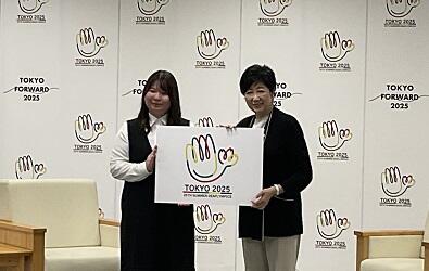 デザインしたエンブレムのパネルを持つ多田さん（写真左側）と小池知事（写真右側）