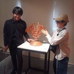 ONCE美術館で展示物に実際に手で触れて鑑賞する川本さんと伊奈さん
