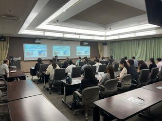 大学について説明を受ける見学者一行
