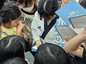 小学生にサインを求められ、囲まれている星野さん