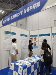 展示ブースで佐久間講師が研究を紹介する様子
