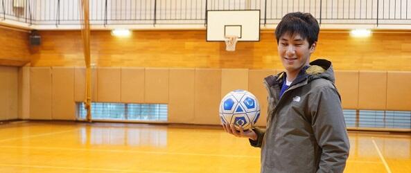 春日キャンパス体育館でブラインドサッカーのボールを持つ近藤さん