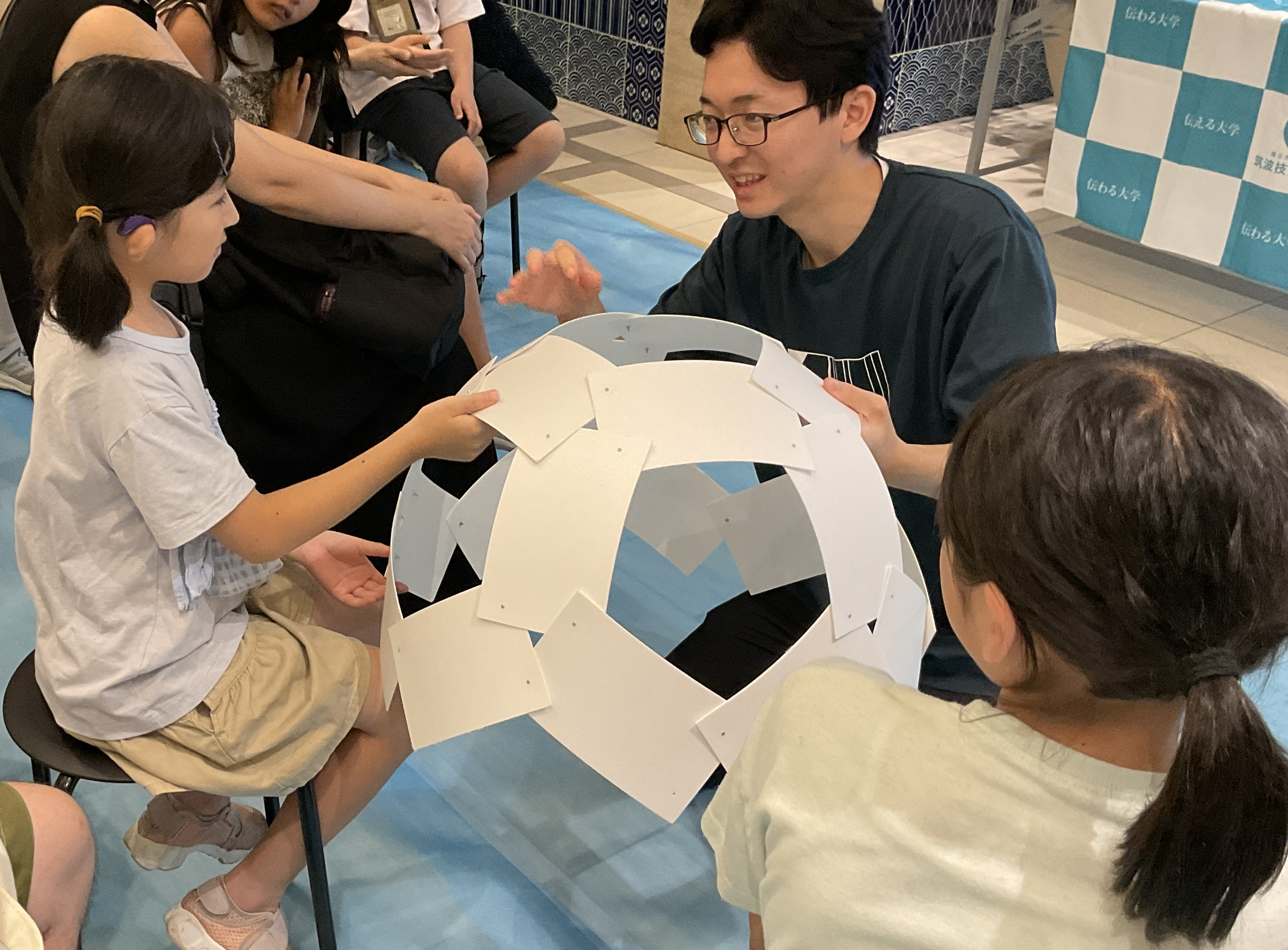 ベニヤ板ドームの模型について説明する様子