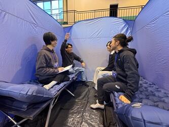 避難用テントの中で座って体験している様子