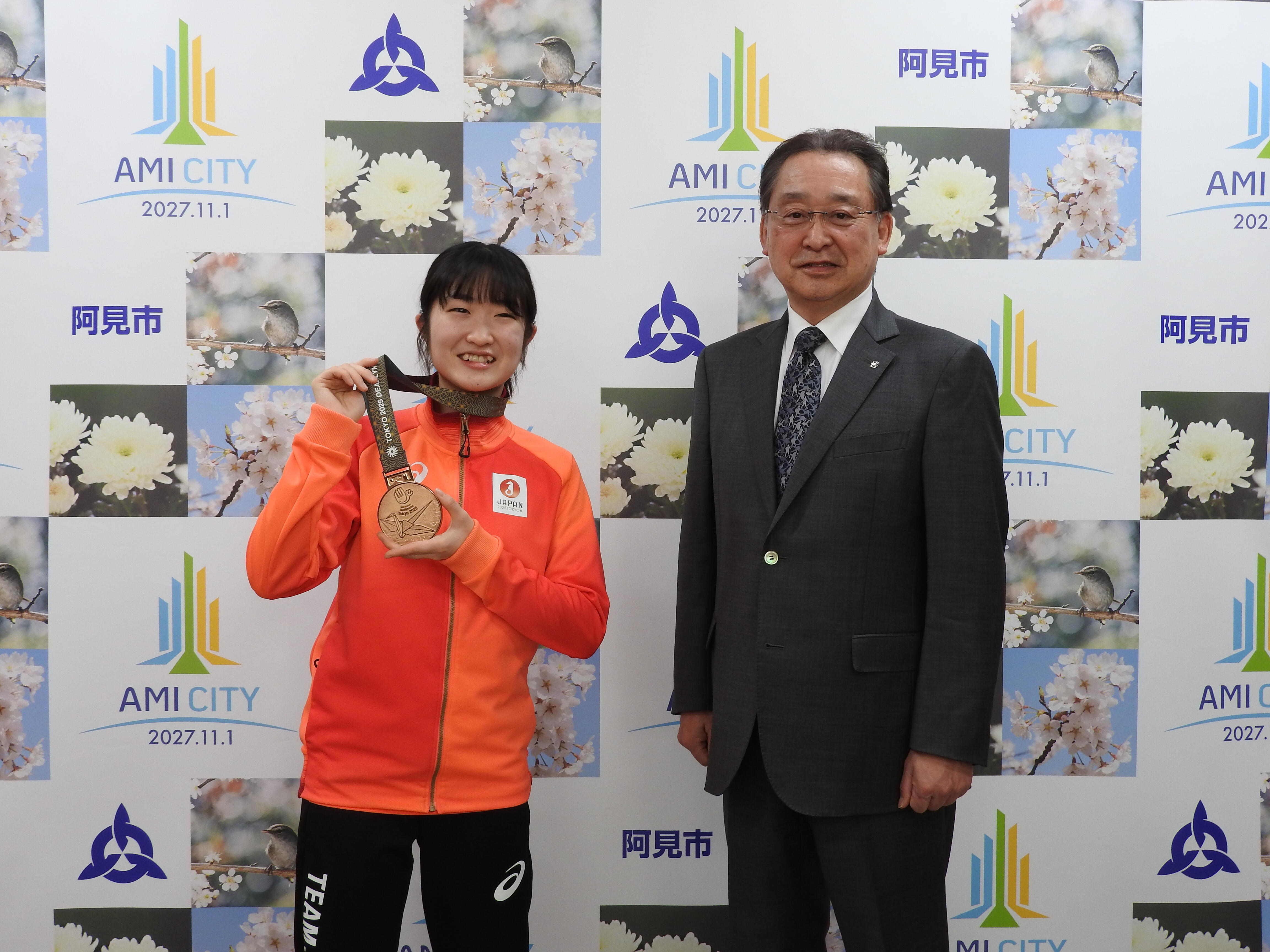 メダルを掛ける星野選手と千葉町長の写真