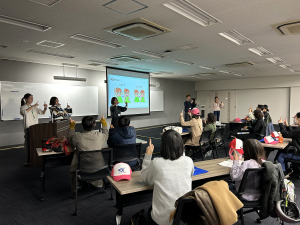 学生が児童・生徒に手話で挨拶を教える様子