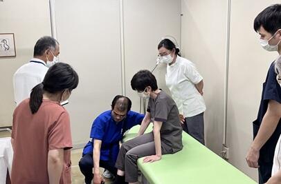 麻痺患者の靴の脱がせる際の転倒リスクについて説明する松枝講師の写真