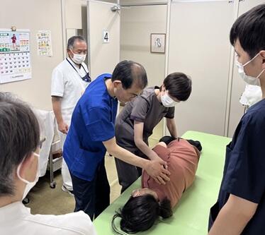 片麻痺患者の臥位から座位への体位変換について指導する松枝講師の写真