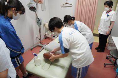 森嶋研修生より施術後の診療台の清掃・消毒について指導を受ける様子
