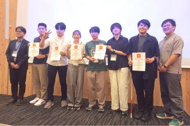 大会長の中澤先生とプログラム委員長の福森先生に挟まれて並び立つ審査員選考の受賞者たちの写真。右から2番目が川本さん