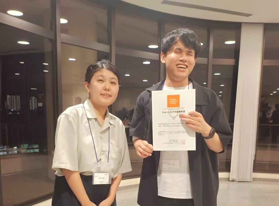 賞状を手に微笑む川本さん(右)と隣に立つ河野さんの写真