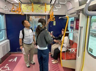 視覚コースの学生が吊り革の高さを確かめている様子の写真