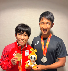 それぞれにメダルを首にかけた半谷さんと川村さんの笑顔のツーショット